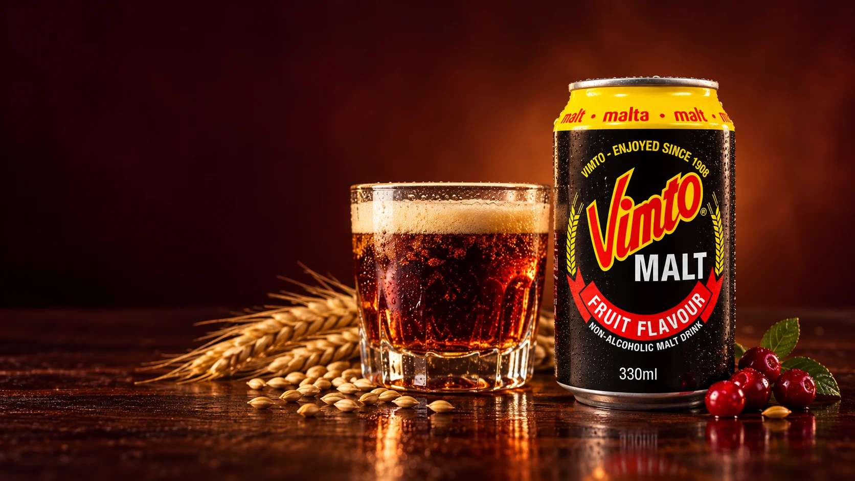 Canette Vimto Malt, verre de boisson ambrée, épis de blé et fruits rouges sur une table sombre.